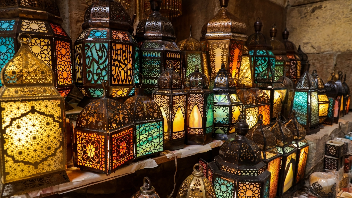 Vibrant and colorful handcrafted Egyptian glass lanterns and copper lamps hanging in the narrow alleys of Khan el-Khalili bazaar.